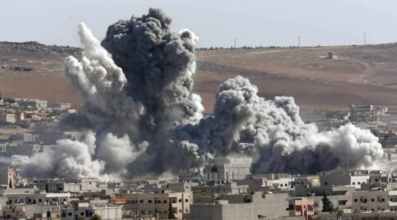 Thick smoke from an airstrike by the US-led coalition rises in Kobani, Syria, as seen from a hilltop on the outskirts of Suruc, at the Turkey-Syria border, Wednesday, Oct. 22, 2014. Kobani, also known as Ayn Arab, and its surrounding areas, has been under assault by extremists of the Islamic State group since mid-September and is being defended by Kurdish fighters. (AP Photo/Lefteris Pitarakis)
